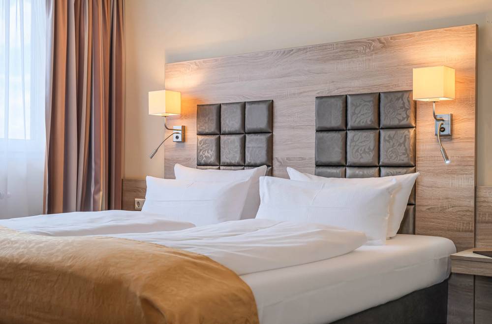 Blick auf das Doppelbett einer Suite im Suite Hotel Leipzig