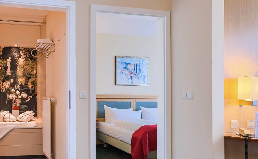 Blick auf das Bad und das Schlafzimmer einer Suite im Suite Hotel Leipzig